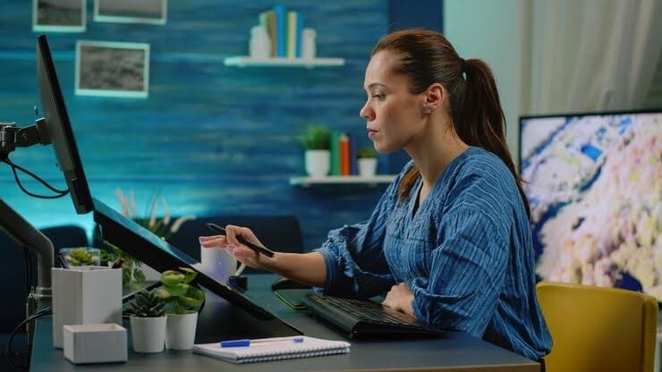 Mulher usando caneta digital em mesa digitalizadora